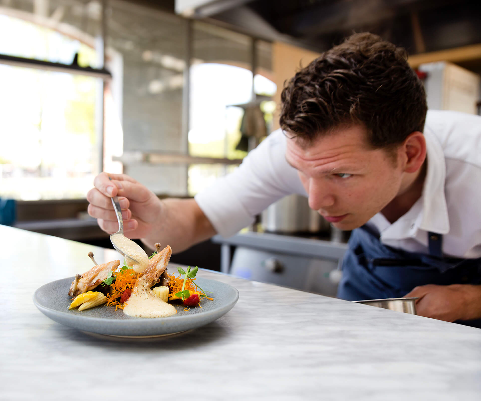 chef-plates-dish-on-counter-large